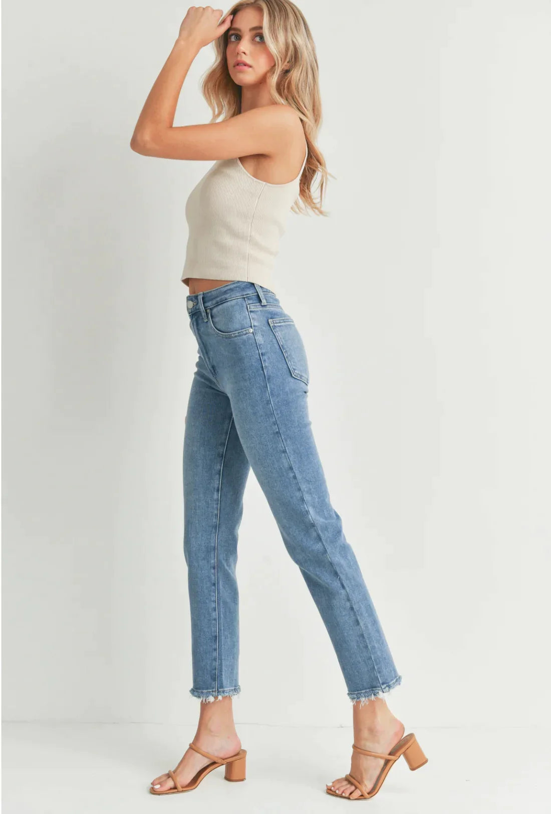 Woman in a white tank top and jeans featuring Hem Bust Jeans with pockets and hem detail