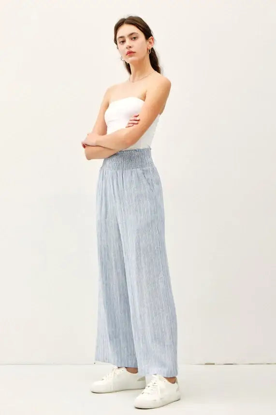 Woman wearing striped linen-rayon wide leg pants with elastic waistband and white tube top