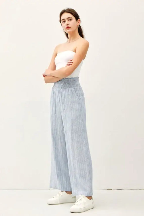 Woman wearing striped linen-rayon wide leg pants with elastic waistband and white tube top