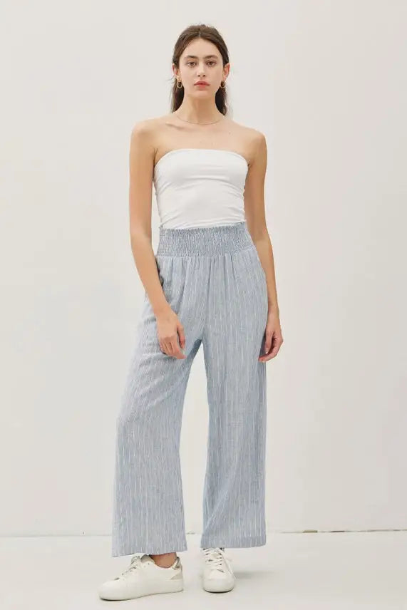 Woman wearing striped linen-rayon wide leg pants with elastic waistband and white tube top