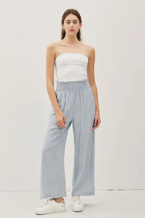 Woman wearing striped linen-rayon wide leg pants with elastic waistband and white tube top