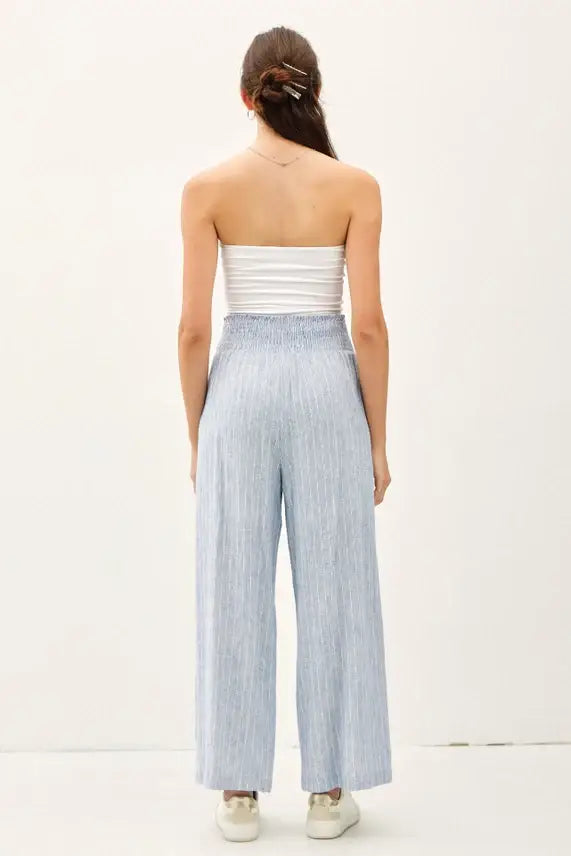 Woman wearing striped linen-rayon wide leg pants with elastic waistband and white tube top
