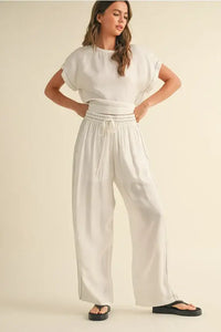 Woman in a white two-piece outfit featuring elastic band waist pants for comfort and style