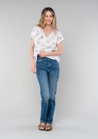 Woman modeling floral short dolman sleeve button top with distressed jeans and brown sandals