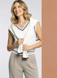 Woman modeling the white V-neck supply Jessie vest with black stripes and light brown pleated trousers