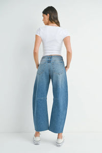 Woman in wide leg denim showcasing THE SEAMED BARREL WILD LEG BLACK WASH JEANS