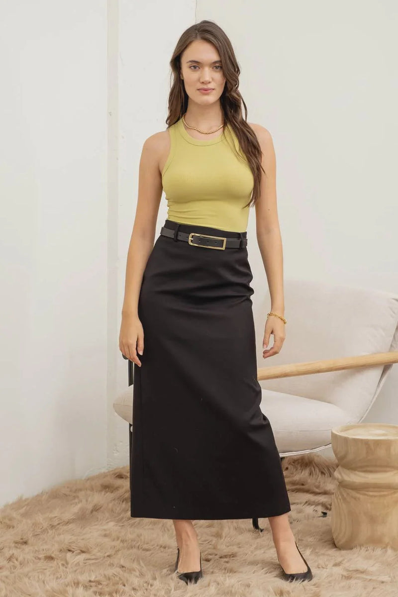 Woman in a yellow sleeveless top and black skirt, exuding boho free spirit style