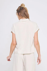Woman wearing beige collared bow linen button-down shirt from COLLARED BOW LINEN collection