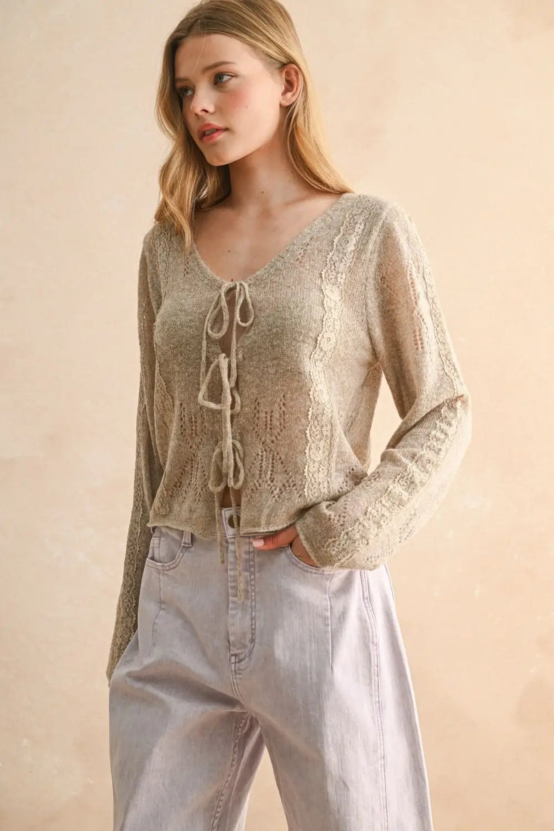 Woman wearing beige knitted cardigan with tie-front detail from Lace Contrastied Tie Front Knitted Cardigan