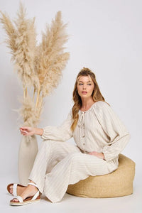 Woman wearing beige pinstripe linen boho chic clothing with coconut buttons and side tie pants