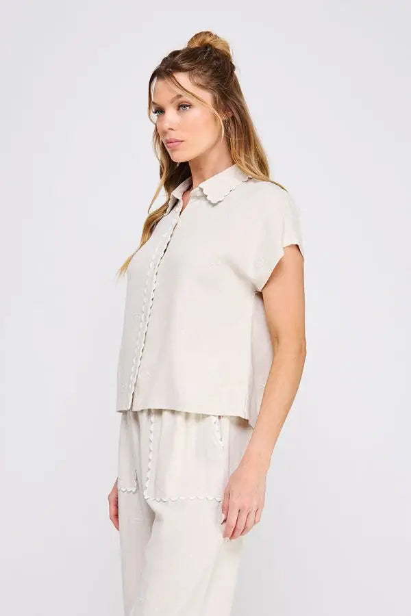 Woman wearing beige collared bow linen pajama set featuring a button-down shirt