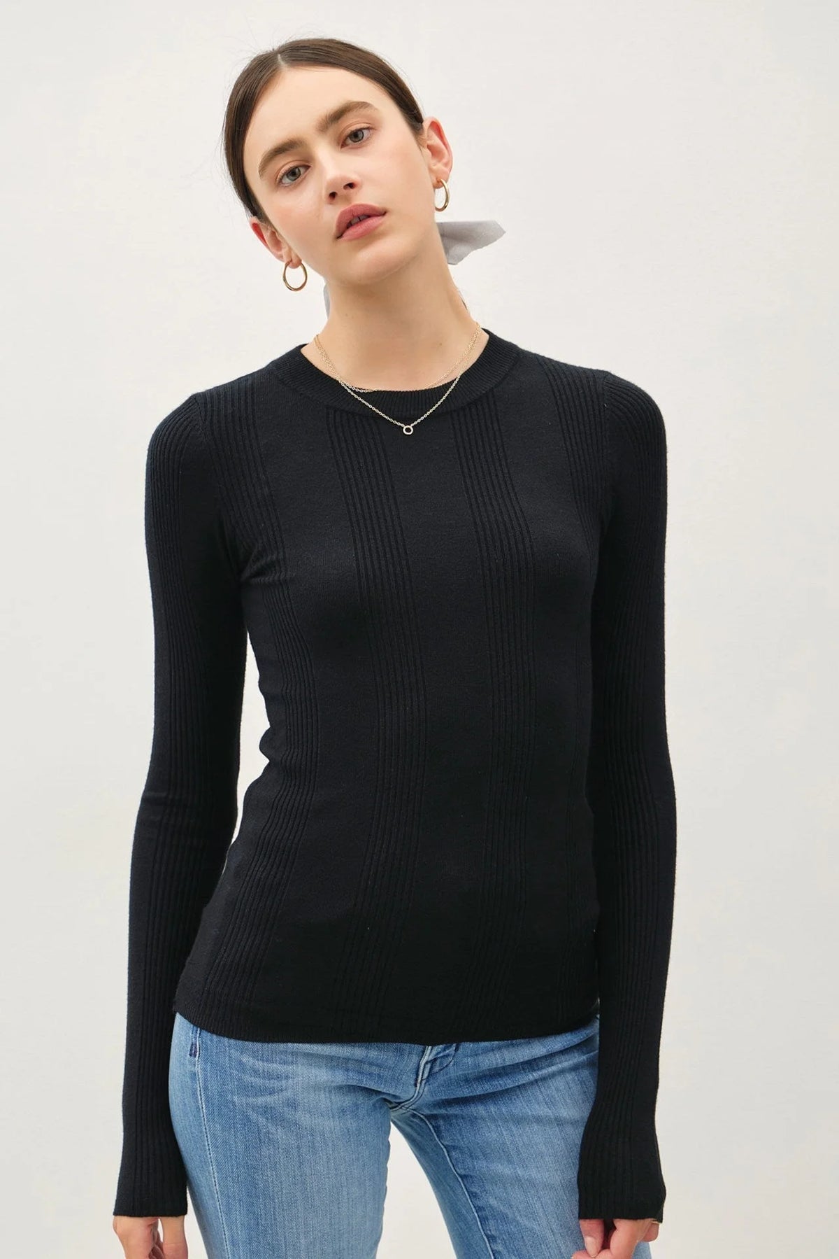 Woman wearing a black ribbed long-sleeve crew neck top in the BASIC PATTERNED KNIT SWEATER