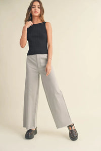 Woman wearing a viscose ribbed knitted boho chic tank top with gray wide-leg jeans