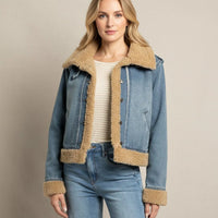 Woman wearing a blue denim supply Henriettta jacket with tan faux shearling lining