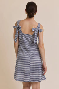 Woman wearing a blue and white stripe sleeveless mini dress with tie shoulders