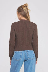 Woman wearing a small cable knit button-down cardigan in brown fabric