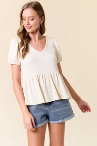 Woman’s cream-colored slub ribbed boho chic top from Shop Daisy with puff short sleeves