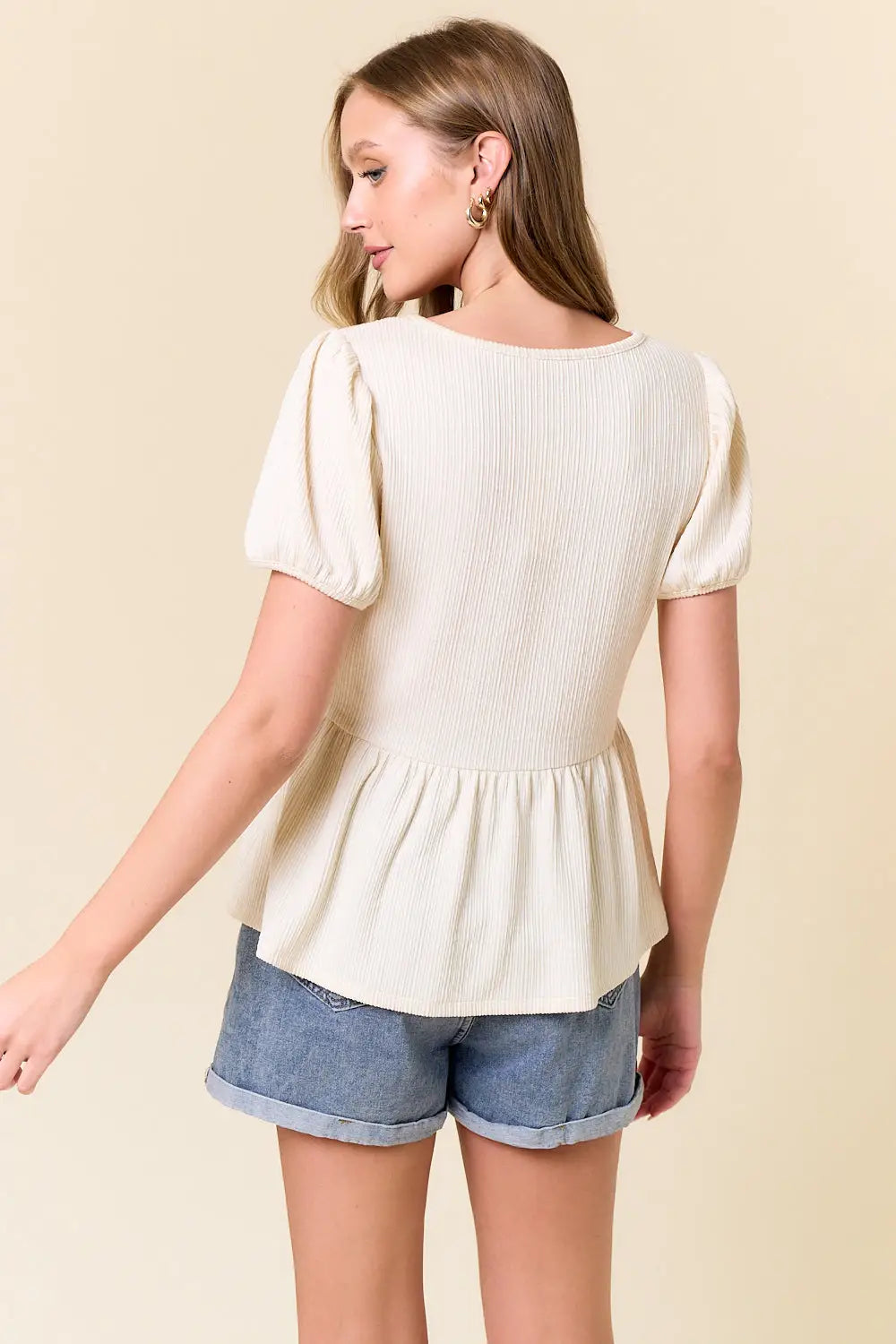 Women’s cream-colored peplum top in slub ribbed fabric from Shop Daisy, perfect for women’s boho chic clothing