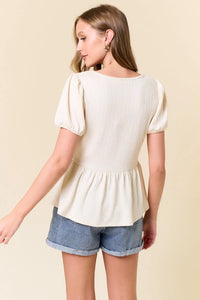 Women’s cream-colored peplum top in slub ribbed fabric from Shop Daisy, perfect for women’s boho chic clothing