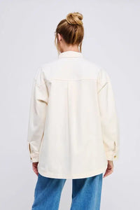 Woman wearing an oversized denim twill shacket in cream color, stylish twill shacket fashion