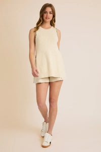 Woman wearing round neck sleeveless cream tank top and shorts set with stitch detail