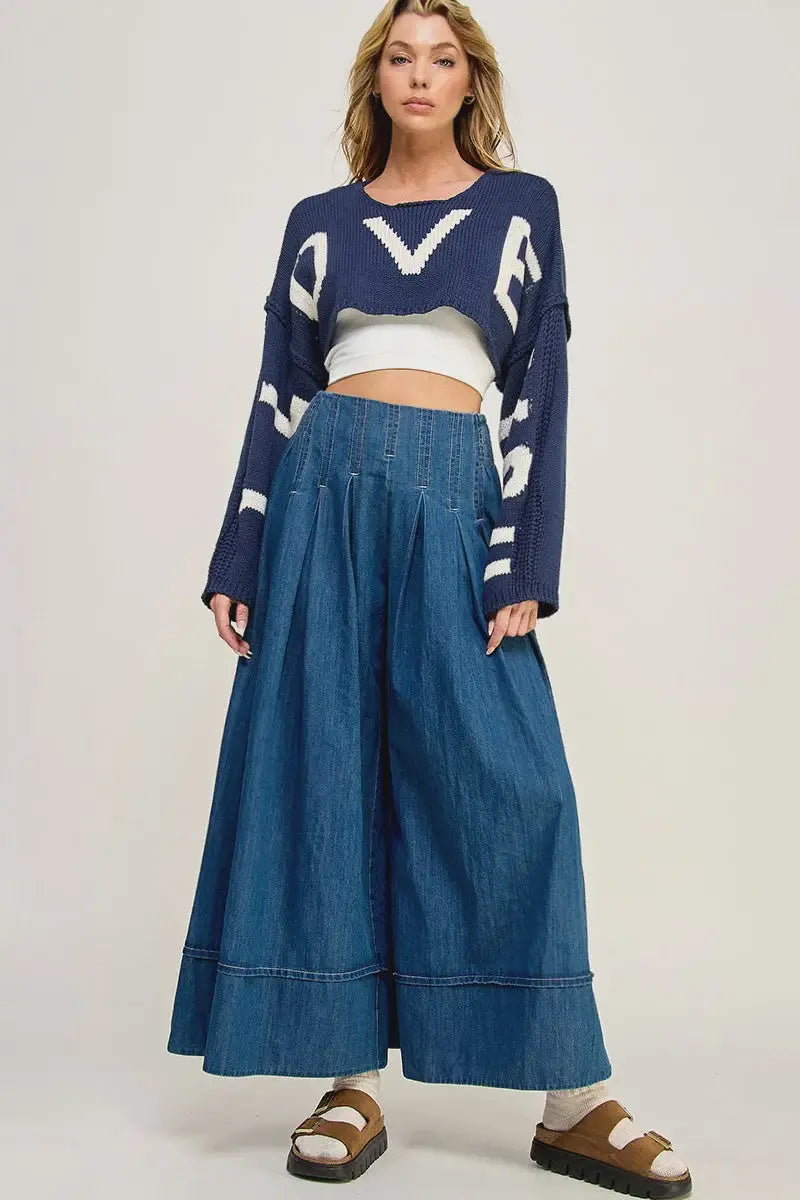 Woman in cropped sweater and denim culottes showcasing women’s boho chic clothing