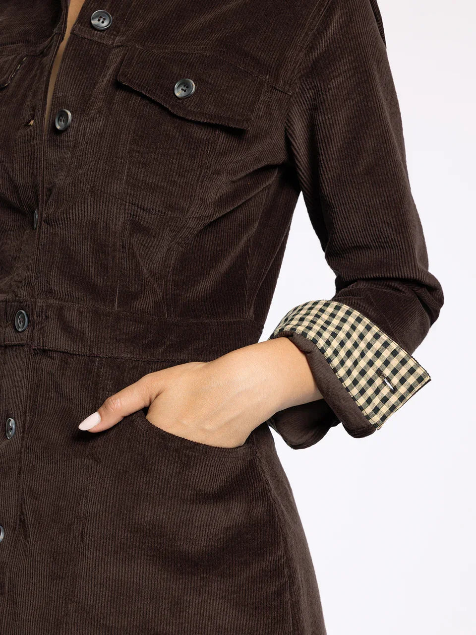Woman wearing dark brown corduroy Gladys Dress with checkered cuff from Thread and Supply