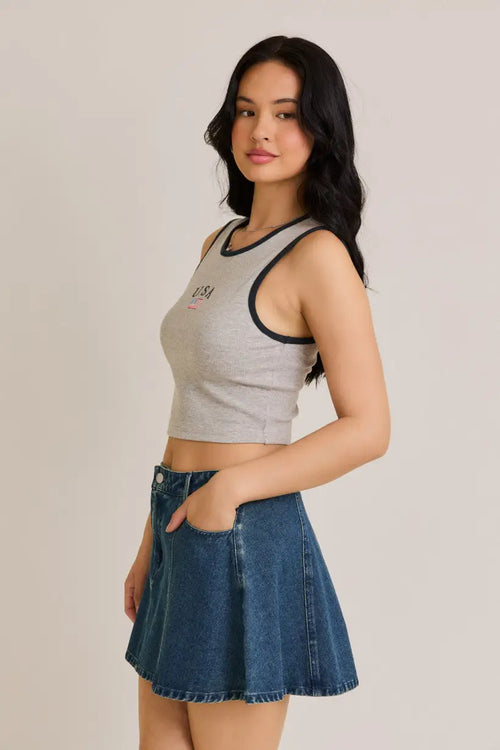 Woman wearing usa american flag sleeveless rib crop top with gray crop top and denim skirt