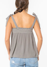 Woman wearing bohemian tie shoulder smocked tank top with tie-shoulder straps