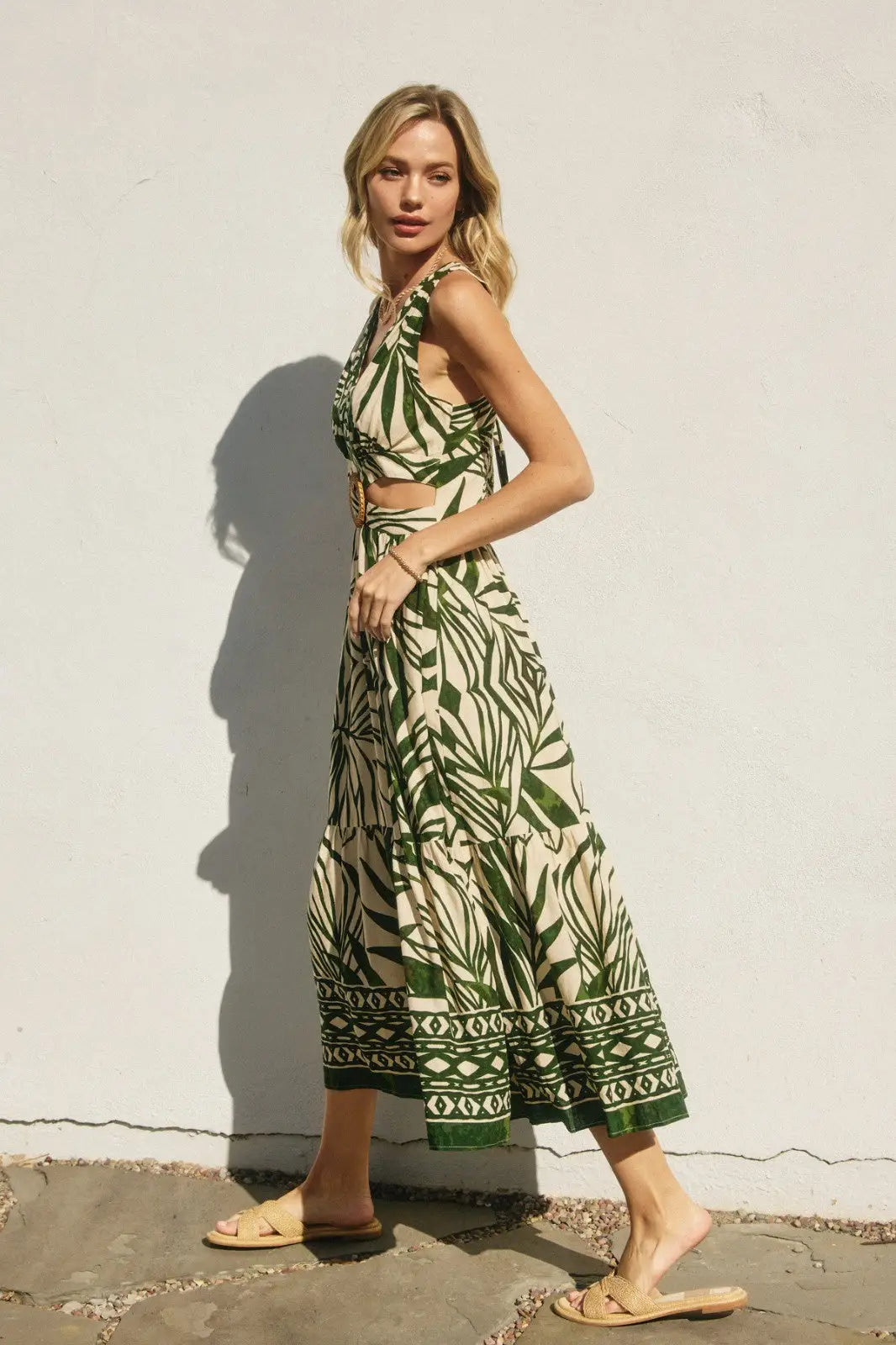 Woman wearing a green and white leaf-patterned maxi sleeveless summer dress