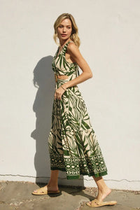 Woman wearing a green and white leaf-patterned maxi sleeveless summer dress