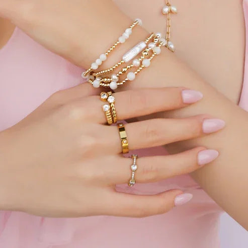 Woman’s hands with 18k gold cubic zirconia jewelry showcasing CZ GOLD RING and stainless steel accents