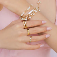 Woman’s hands with 18k gold cubic zirconia jewelry showcasing CZ GOLD RING and stainless steel accents