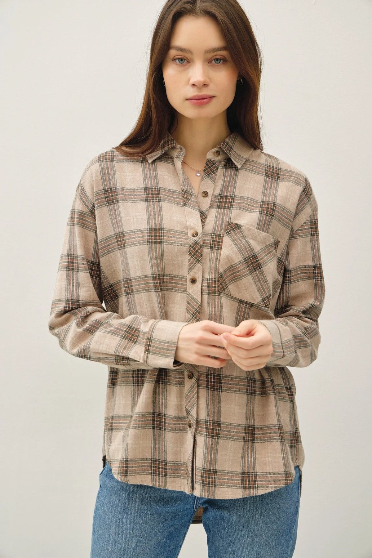 Woman wearing a classic cotton small plaid shirt with long sleeves, collar, and chest pocket