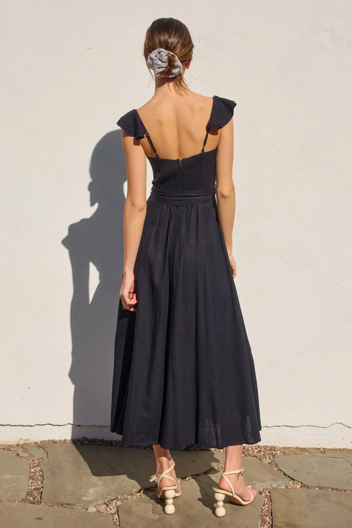 Navy blue HEAVEN SENT Corset Flutter Dress with ruffled straps and cream heels