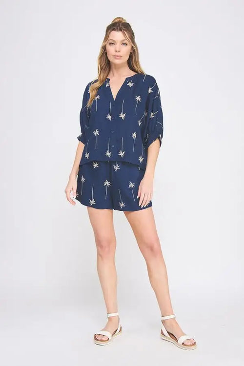 Woman wearing navy palm tree embroidered lined shorts and matching top set for summer style