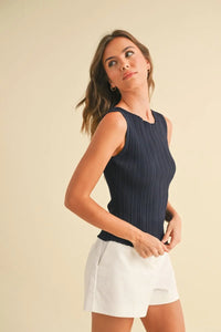 Woman wearing navy viscose ribbed knitted tank top and white shorts, perfect for boho chic clothing