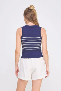 Woman wearing navy and white striped knit sleeveless polo tank top with white shorts