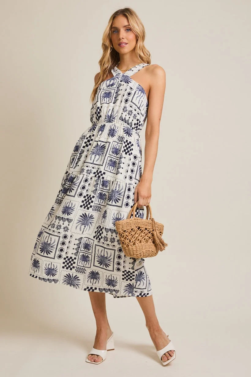 Woman wearing a halter neck abstract print dress with a stylish patterned design