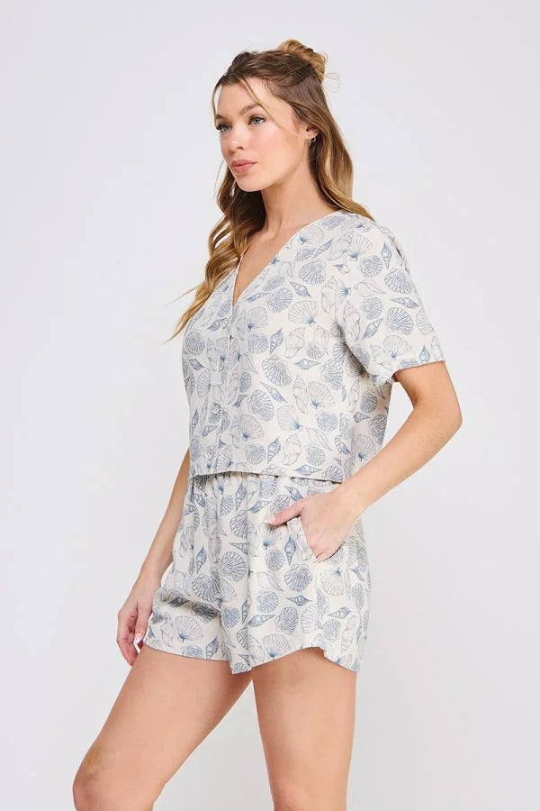 Woman wearing seashell printed linen two-piece shorts set with linen V neck button-up top