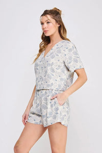Woman wearing seashell printed linen two-piece shorts set with linen V neck button-up top