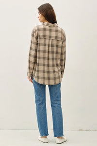 Woman wearing classic cotton small plaid shirt in brown and tan over blue jeans