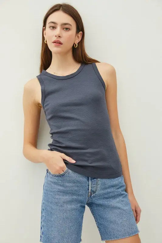 Woman’s ribbed tank top with raised hem paired with denim shorts for boho chic style