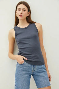 Woman’s ribbed tank top with raised hem paired with denim shorts for boho chic style
