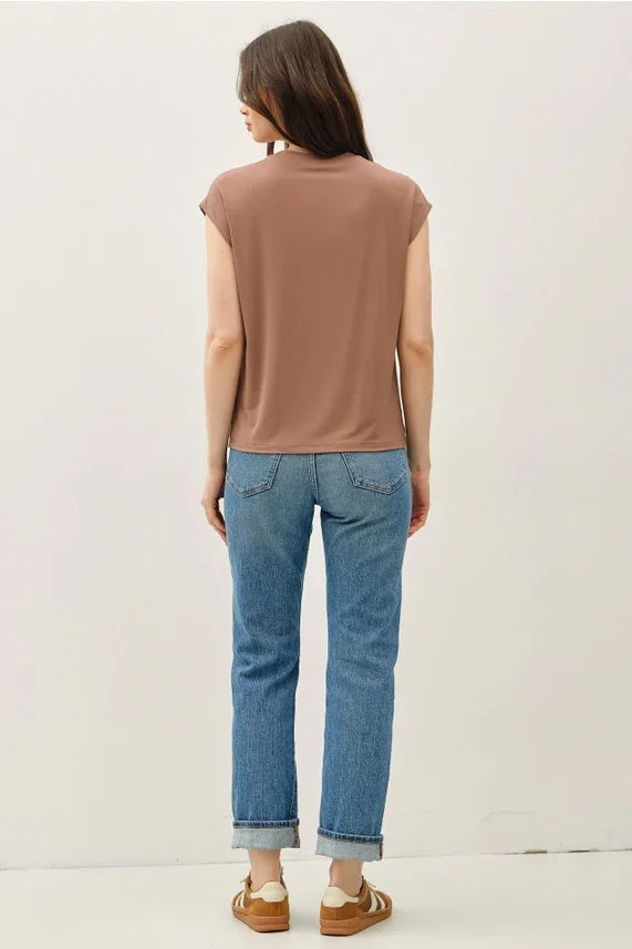 Woman wearing bamboo cap sleeve basic round neck top with blue jeans and sneakers