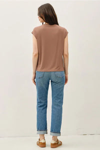 Woman wearing bamboo cap sleeve basic round neck top with blue jeans and sneakers