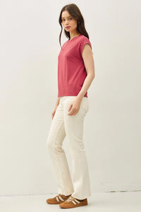 Woman wearing a deep rose bamboo cap sleeve basic round neck top with cream flared jeans