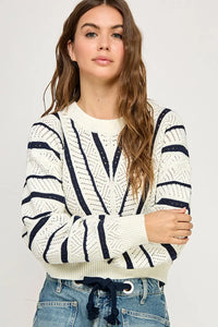 Woman wearing V-Striped Knit Sweater from Shop Daisy, perfect for women’s boho chic clothing