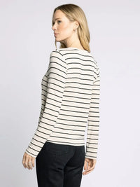 Woman wearing striped long-sleeved shirt from THREAD AND SUPPLY LAUREN TOP, perfect for women’s boho chic clothing