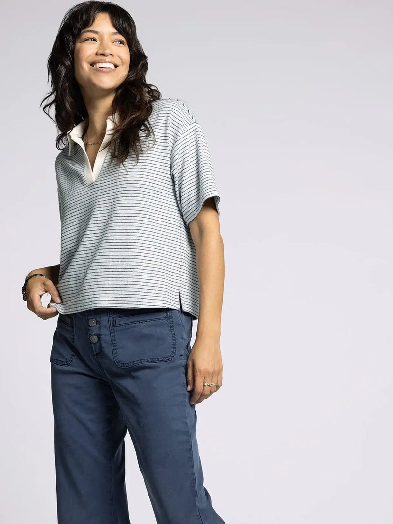 Woman wearing striped polo shirt and blue pants from THREAD AND SUPPLY CALIX TOP, perfect for women’s boho chic clothing at Shop Daisy